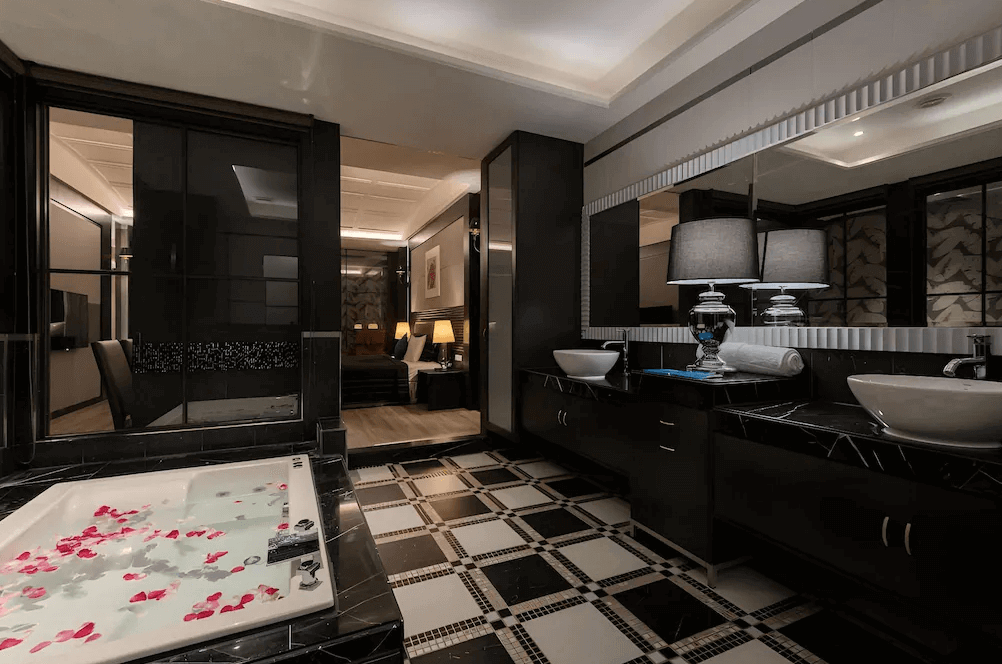 【鳳山住宿】麗馨汽車旅館 奢華浴室套房黑白格紋地磚搭配大型按摩浴缸，浴缸內飄灑玫瑰花瓣，雙洗手台設計營造浪漫氛圍。