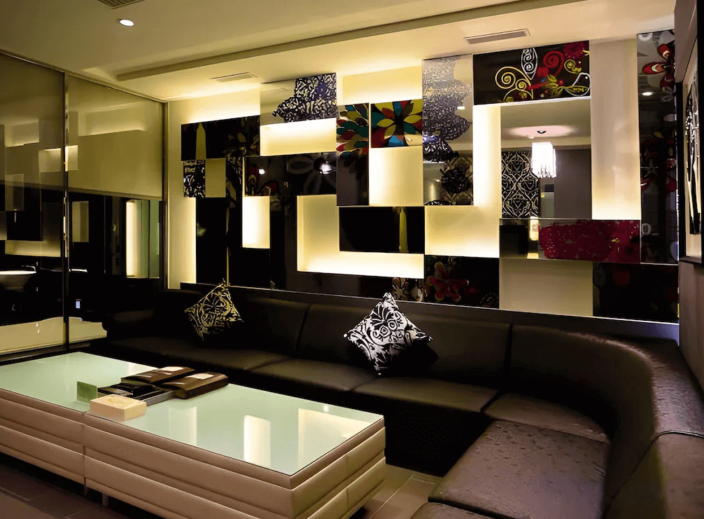 【鳳山住宿】麗馨汽車旅館 交誼休憩空間現代化的休憩區，設有大型皮沙發與玻璃茶几，牆面以彩色裝飾方格點綴，氛圍時尚繽紛。