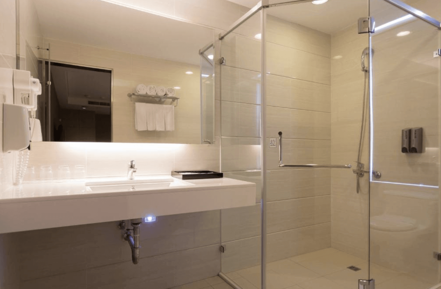 【前金住宿】麗馨精品商旅七賢館 — 明亮乾淨的衛浴空間，配備玻璃淋浴間與洗手台，設計簡潔大方。