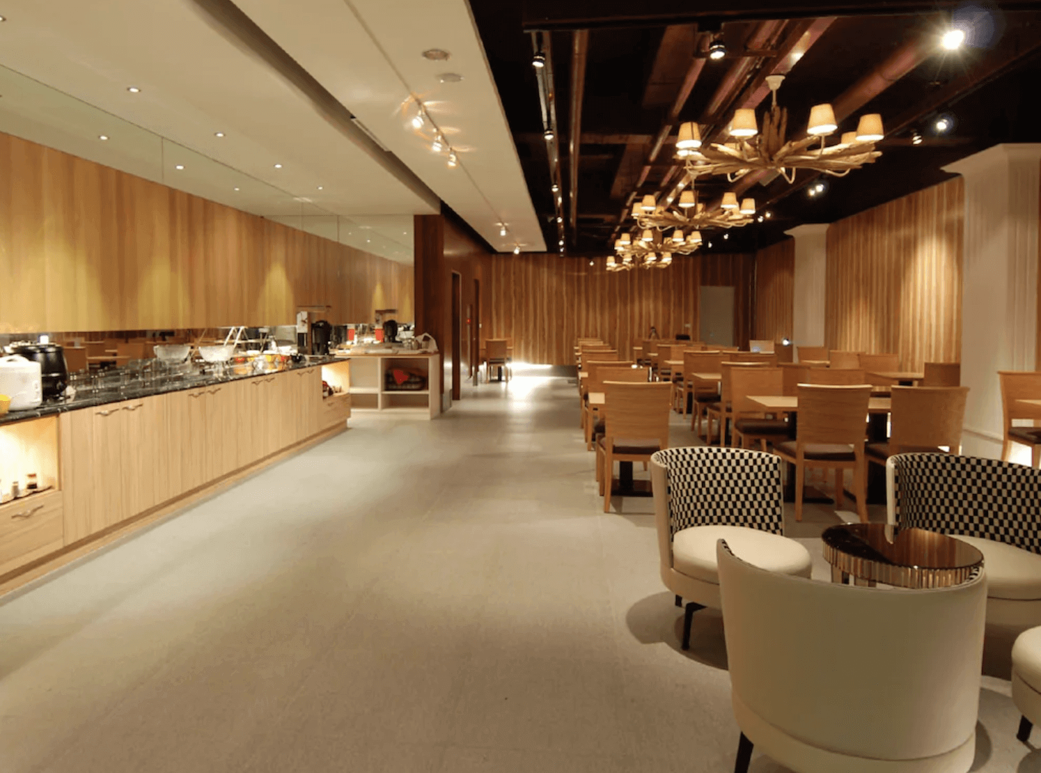 【前金住宿】麗馨精品商旅七賢館 — 餐廳空間以木質與暖色燈光裝潢，提供自助式早餐座位區，氛圍舒適寬敞。