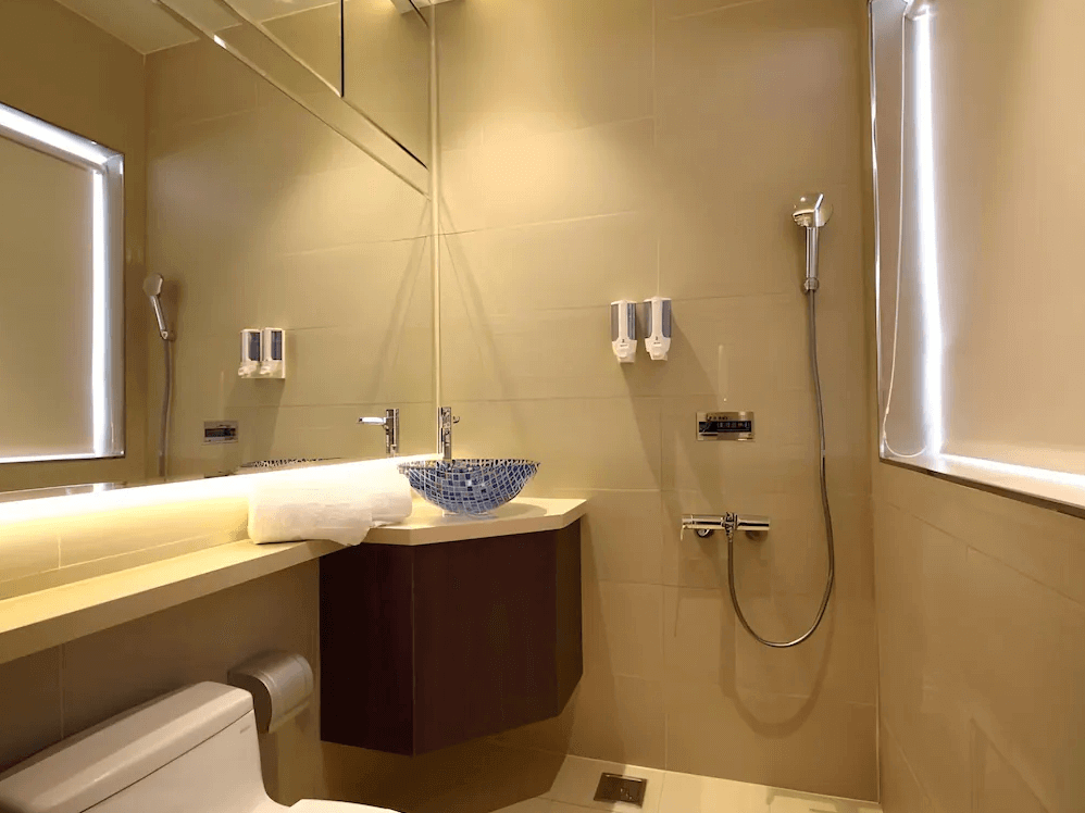 【鳳山住宿】麗馨精品商旅鳳山館 浴室明亮整潔的浴室，配有現代化洗手台、藍色花紋洗手盆與淋浴設備，設計簡約雅緻。