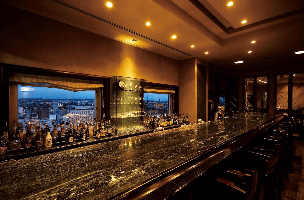 【釧路住宿】ANA皇冠假日飯店釧路頂樓酒吧，氣氛高雅沉穩，設有長型大理石吧檯與城市夜景窗景，是放鬆小酌的絕佳空間。