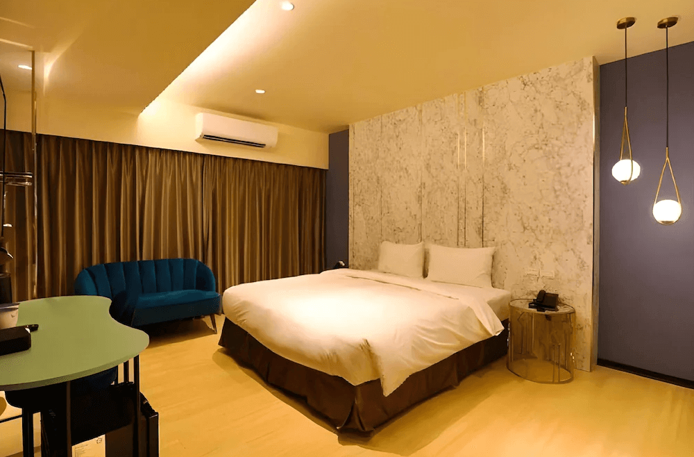 【頭城住宿】宜蘭頭城 Hotel Lounge 朗居文旅 豪華雙人房，採用大理石牆面與溫暖燈光設計，配有舒適沙發與柔和空間氛圍。