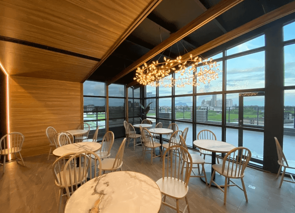 【頭城住宿】宜蘭頭城 Hotel Lounge 朗居文旅 早餐餐廳空間，落地窗可眺望田園景觀，木質調設計與暖黃吊燈營造悠閒氛圍。