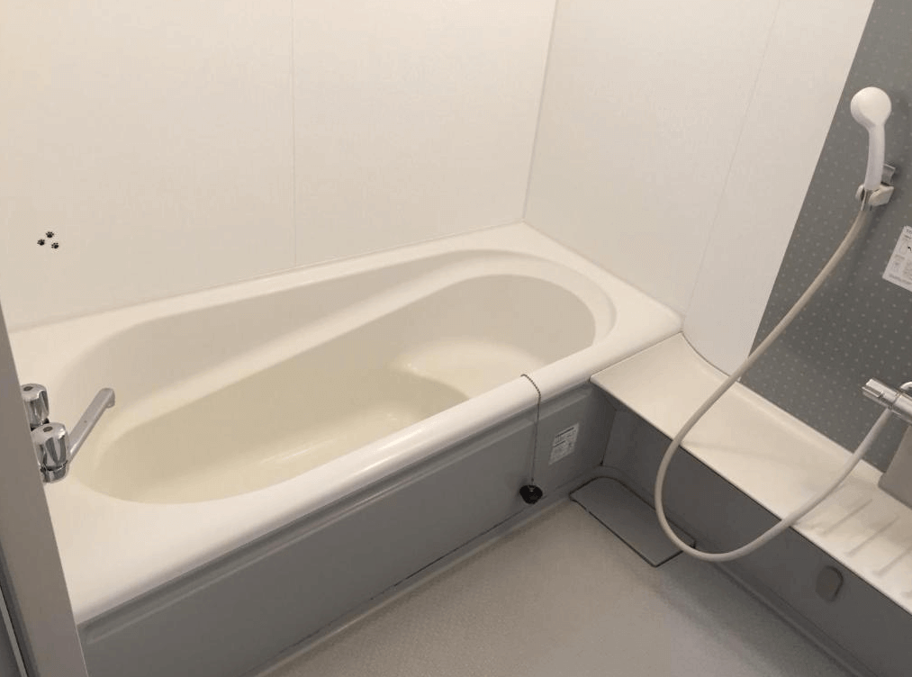 【網走住宿】Imodango村民宿」的浴室空間，設有寬敞浴缸與手持花灑，採用明亮潔淨的白色牆面，提供舒適的泡澡與淋浴體驗。