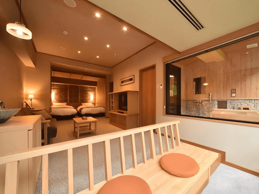 【釧路住宿】La Vista阿寒川飯店雙床房一景，附設觀景浴池與休息區，整體以自然木色與柔光設計打造溫馨高雅的住宿氛圍。