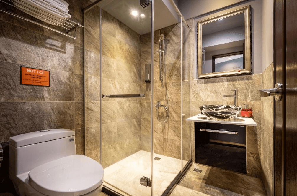 【瑞芳住宿】九份不厭晴民宿｜衛浴空間乾濕分離設計，石紋牆面搭配玻璃淋浴間與花紋洗手盆，整體風格現代且乾淨明亮。