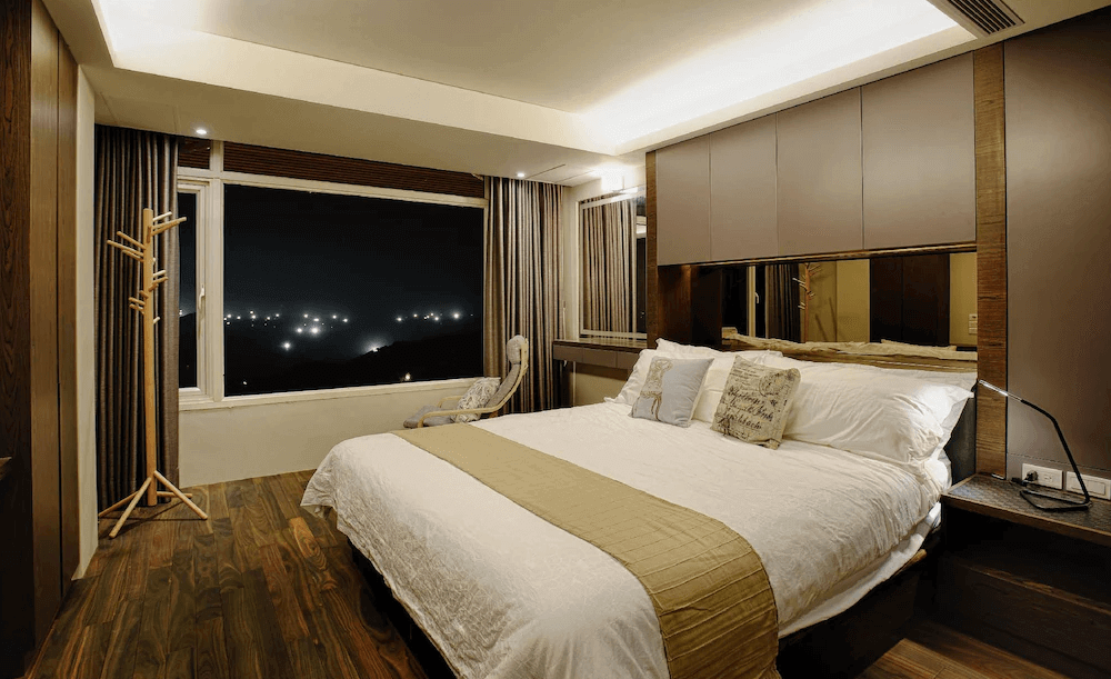 【瑞芳住宿】九份山城逸境｜夜景景觀房，木質地板與沉穩色調搭配大面窗景，窗外可觀賞九份山城夜色燈海，呈現寧靜浪漫氛圍。