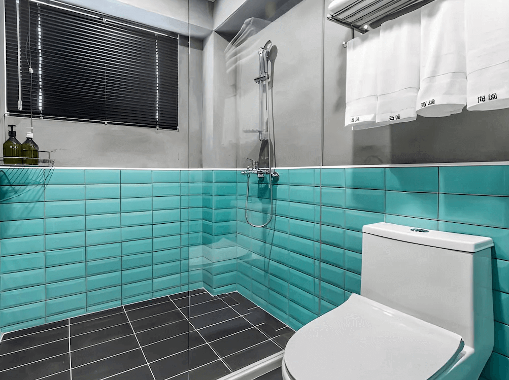 【瑞芳住宿】九份海論｜衛浴空間以灰色牆面與藍綠色磁磚設計，乾濕分離並保持整潔明亮，風格清新具現代感。