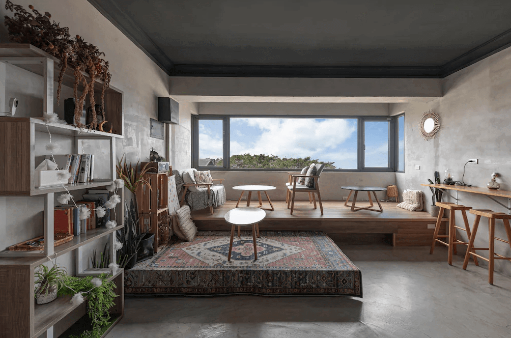 【瑞芳住宿】九份海論｜公共交誼廳採寬敞開放設計，大面窗景可欣賞九份山海美景，配有書架與咖啡桌，營造溫馨放鬆的住宿氛圍。