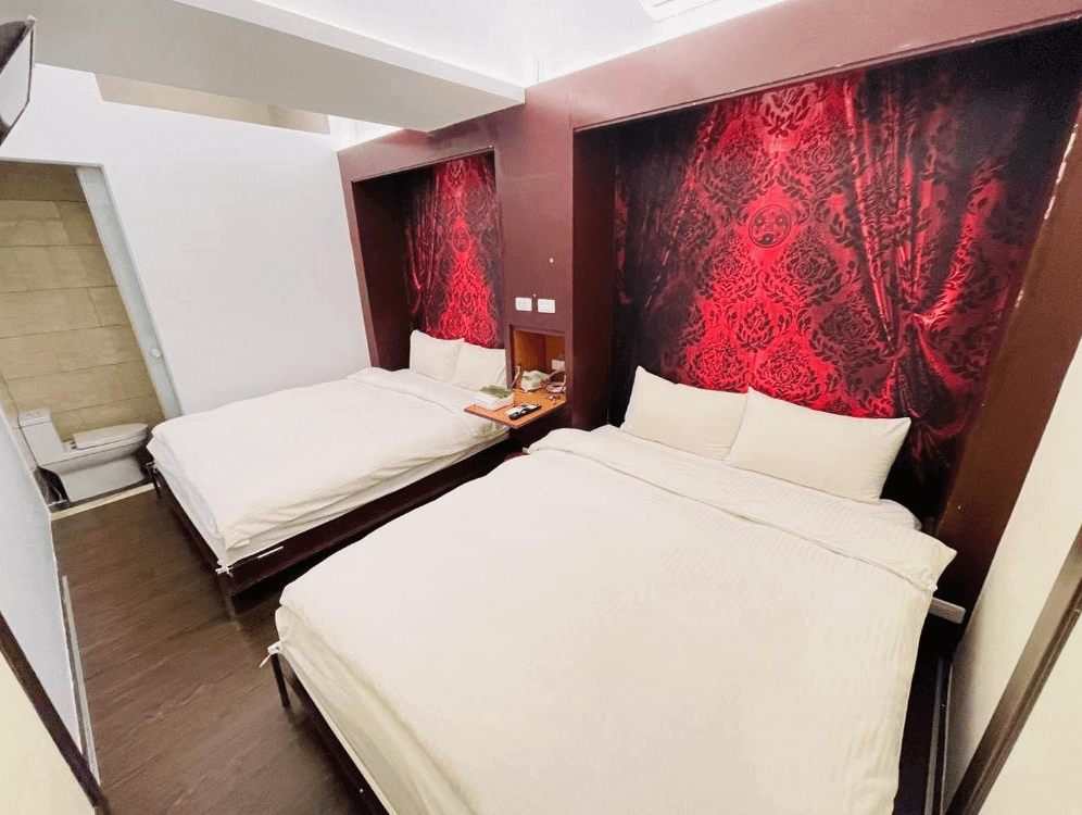 【瑞芳住宿】井上天花｜雙床房內裝以紅色絨布牆面為主題，搭配白色床鋪與柔光燈具，呈現濃厚的東方復古風格。
