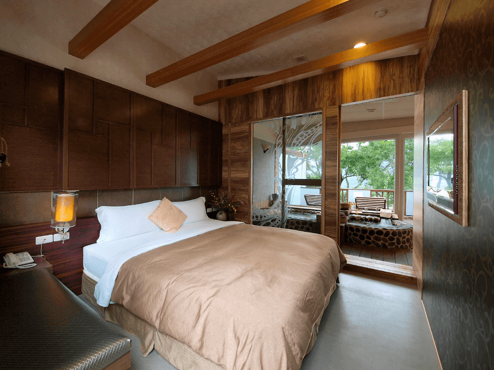 【六龜住宿】高雄六龜【國蘭花園Villa會館】溫泉套房，木質天花與牆面設計溫馨典雅，附設半露天湯池區，透過玻璃窗可眺望戶外綠景。