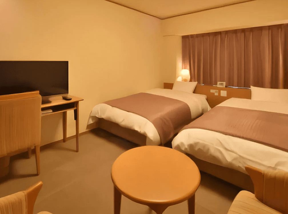 【釧路住宿】多米高級酒店－釧路天然溫泉雙床房，柔和燈光與暖色調設計營造溫馨氛圍，房內配有電視、桌椅與兩張床。