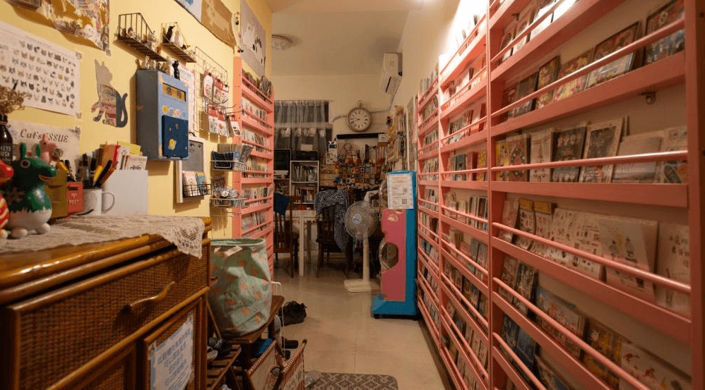 【台南寵物友善住宿】太陽慢慢走 Red Letter Day 民宿的文具展示區，擺滿色彩繽紛的明信片與插畫文創商品，整體空間溫馨又充滿創作氣息。