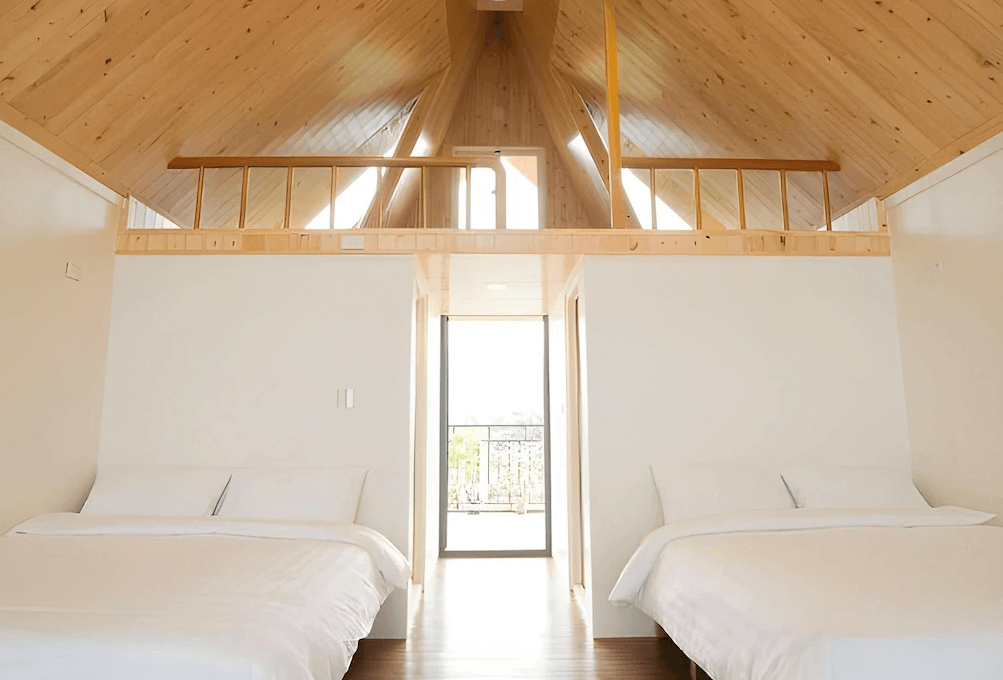 【頭城住宿】宜蘭工匠家小木屋民宿 閣樓四人房，溫暖木質斜屋頂與自然採光設計，兩張大床空間寬敞明亮，適合親子或好友入住。