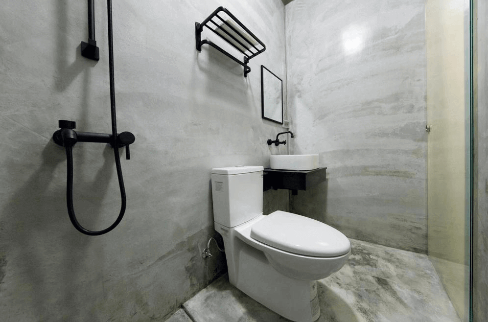 【台南寵物友善住宿】怠宿 SLOW 衛浴空間，以水泥灰色系為主體，配有黑色淋浴設備與現代感洗手台，整體俐落乾淨。