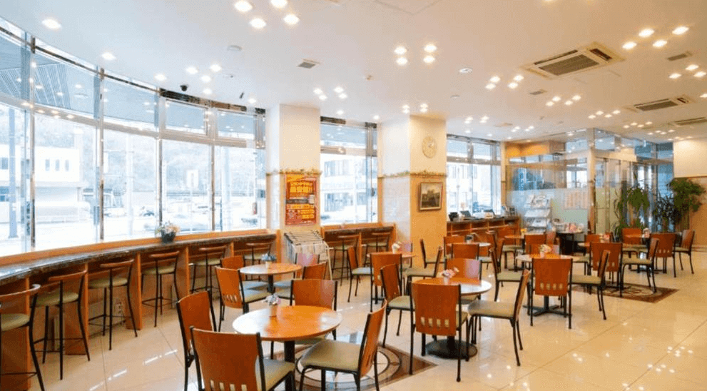 【網走住宿】「東橫INN北海道鄂霍次克網走站前」的早餐餐廳，空間明亮寬敞，大面落地窗引入自然光線，提供多樣座位區與自助式早餐服務。