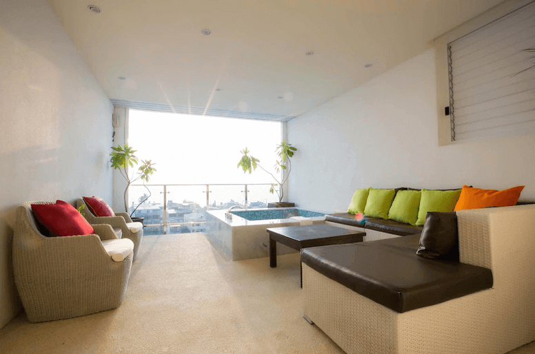 【枋寮住宿】「枋客文旅 FangLiao Hotel 海景陽台套房，配備戶外泡湯池與舒適沙發區，彩色抱枕與陽光灑落營造放鬆氛圍，遠眺海景視野遼闊。」