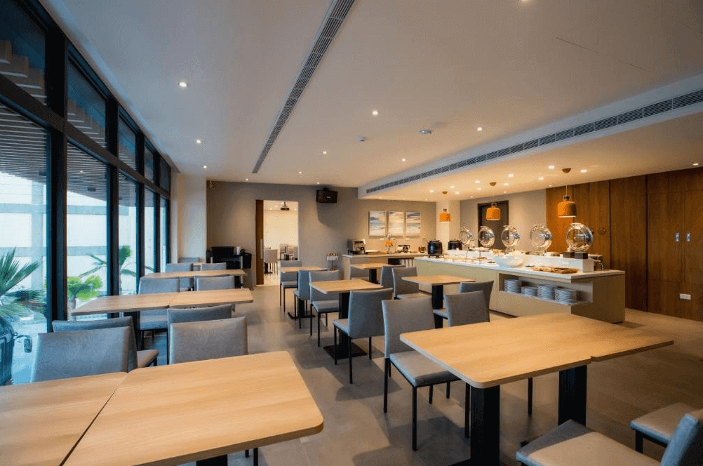 【枋寮住宿】「枋客文旅 FangLiao Hotel 餐廳早餐區，設有明亮落地窗與自助吧檯，提供多樣中西式餐點，整體空間寬敞現代。」