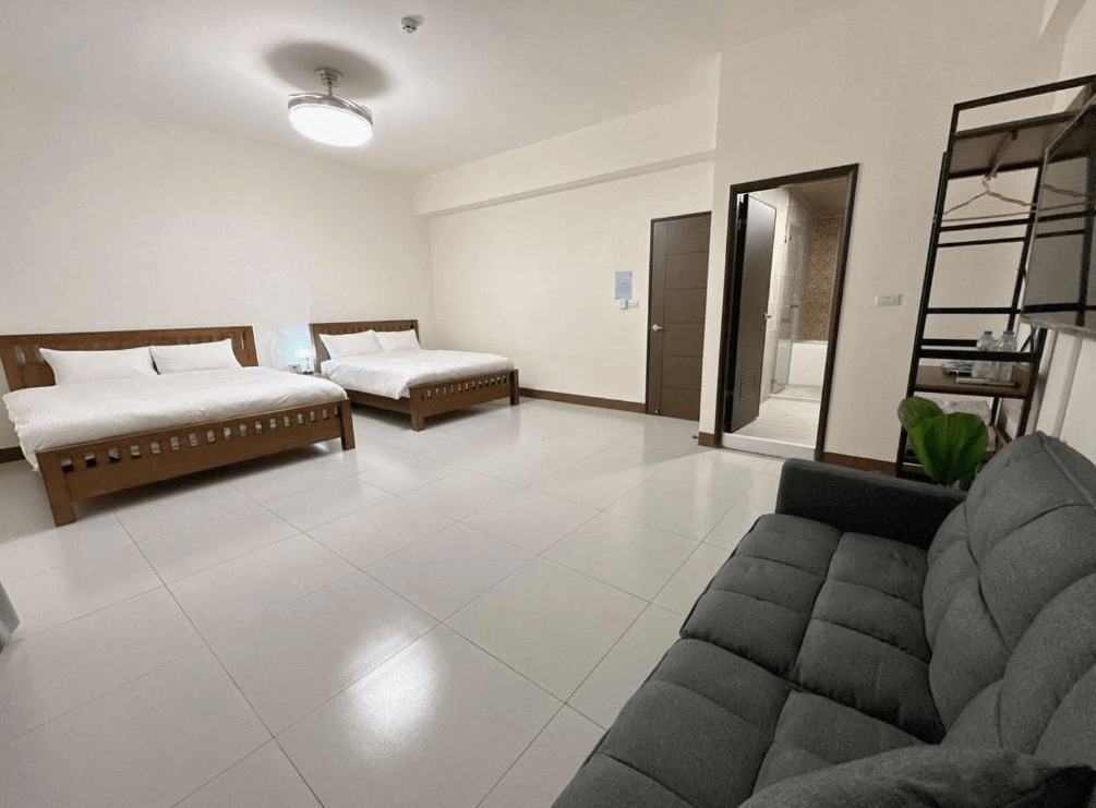 【枋寮住宿】「枋寮18遛遛居 四人房，兩張雙人床配置整齊，空間寬敞明亮，附有沙發、衣架與獨立衛浴，適合家庭或團體入住。」