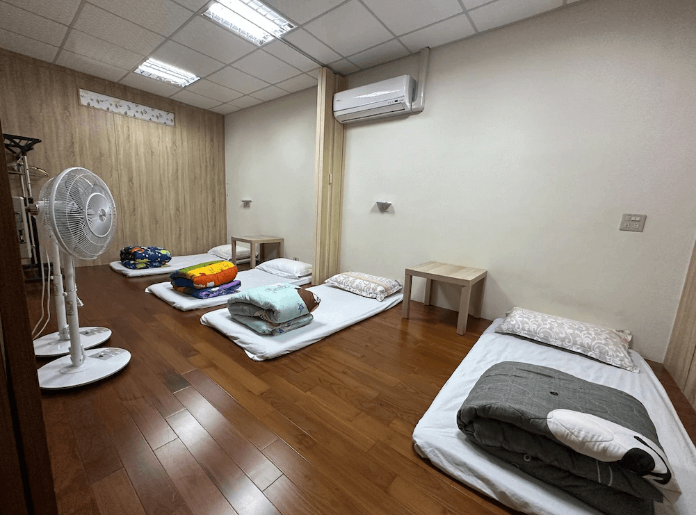 【枋寮住宿】「枋寮枋居背包客棧 榻榻米通舖房型，鋪設多組床墊與被褥，木質地板整潔寬敞，提供電風扇與小桌，適合團體入住。」