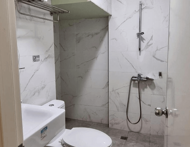 【瑞芳住宿】清芳民宿浴室空間，採用白色大理石紋磁磚，設有乾溼分離淋浴區、洗手台與馬桶，整體明亮乾淨，設備新穎齊全。