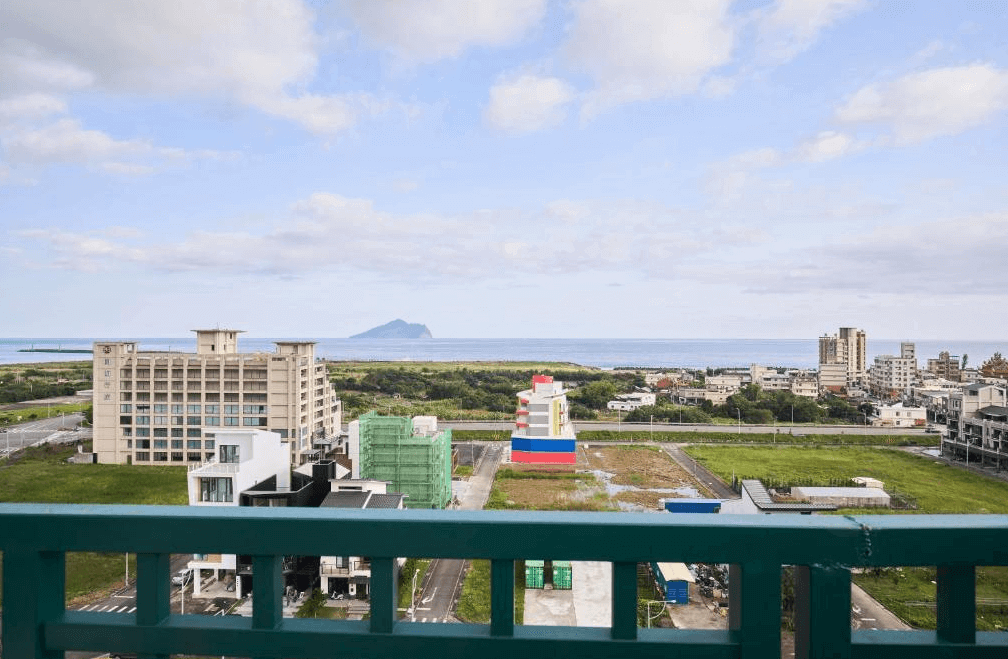 【烏石港住宿】第一山海行館高樓層陽台景觀,遠眺龜山島與太平洋海景,俯瞰頭城鎮建築與綠地,視野遼闊,是放鬆觀景的絕佳位置。