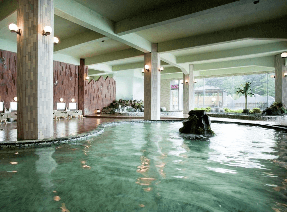【網走住宿】「網走湖莊大飯店」的室內溫泉浴場，採用大片落地窗設計，可邊泡湯邊欣賞庭園與自然景色，池水清澈寬廣，環境明亮放鬆。