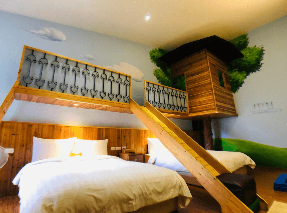 【台南寵物友善住宿】蝸聚民宿親子樹屋主題房，房內設有木質閣樓與樹屋造型裝飾，搭配雲朵牆面與溫暖燈光，營造童趣森林氛圍。