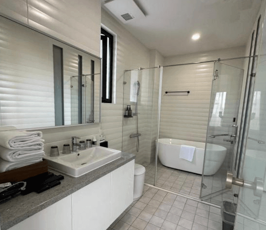 【台南寵物友善住宿】衡定理・畃雨民宿的衛浴空間，採全白色系設計與玻璃乾濕分離，內有獨立浴缸與大型鏡面洗手台，明亮整潔且具有現代感。