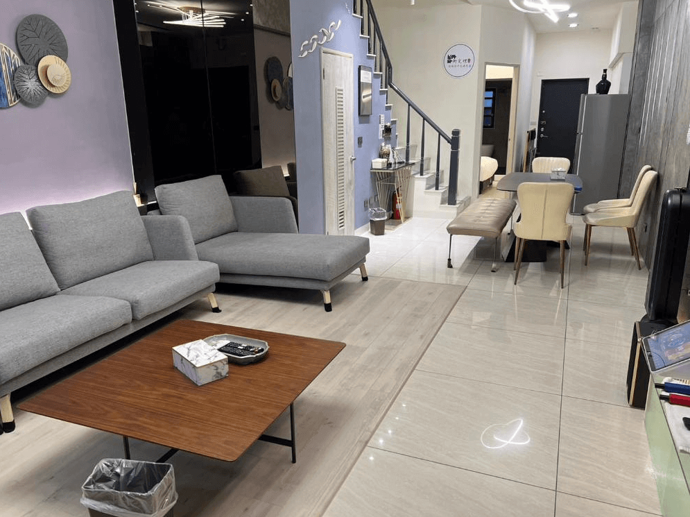 【台南寵物友善住宿】衡定理・畃雨民宿的公共空間，結合客廳與餐廳設計，設有灰色沙發、木質茶几與長桌餐椅，空間寬敞明亮，氛圍溫馨舒適。