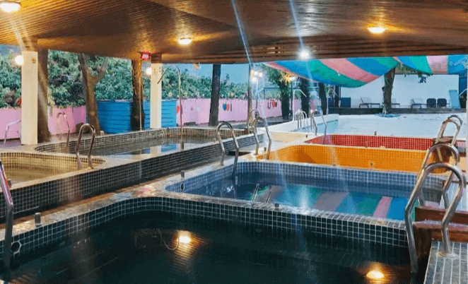 【六龜住宿】高雄六龜【道時尚悠然山莊】溫泉區設施，多個不同溫度與深度的泡湯池設於半露天空間，夜晚燈光倒映水面，氛圍寧靜放鬆。