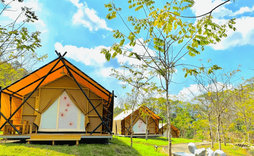 【六龜住宿】高雄六龜【遠山望月溫泉風呂露營區】豪華露營區白天景觀，整齊排列的三角帳篷搭配藍天綠意，環境清幽，適合親子與情侶同遊。