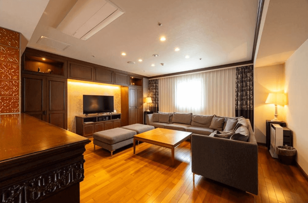 【釧路住宿】釧路世紀城堡飯店貴賓客廳，寬敞舒適的空間搭配大型灰色沙發與暖黃燈光，散發歐式典雅氣息，適合家人或團體入住。