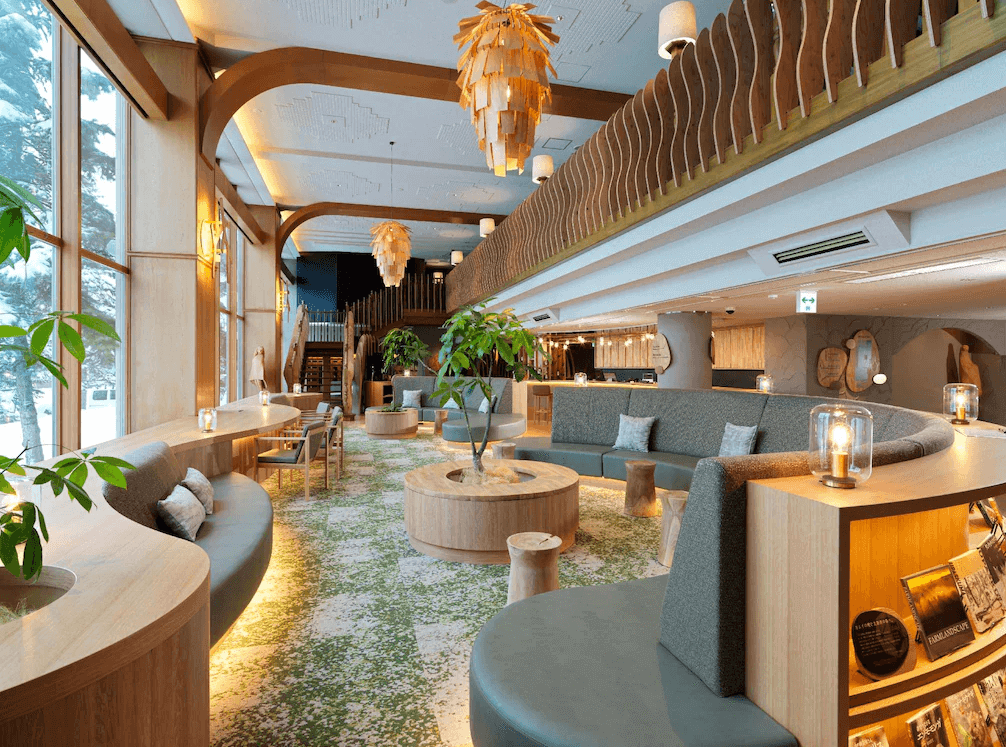 【釧路住宿】阿寒之森鶴雅度假村大廳休息區，挑高空間搭配木質裝飾與綠意植栽，營造森林系度假氛圍，充滿自然光與溫暖色調。