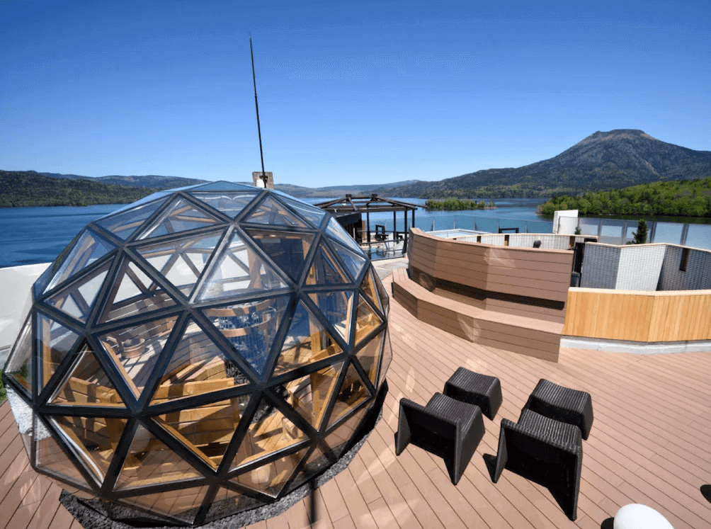 【釧路住宿】阿寒遊久之里鶴雅頂樓露天休憩區，設有玻璃圓頂觀景區與戶外溫泉，可遠眺阿寒湖與山景，感受自然與建築融合的魅力。