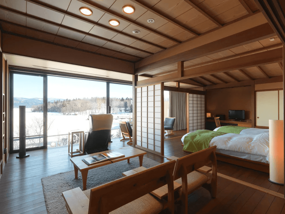【釧路住宿】阿寒鶴雅別莊鄙之座和洋式湖景套房，設有榻榻米起居空間與木質裝潢，大面窗景可欣賞阿寒湖與冬季雪景，展現靜謐優雅的日式氛圍。