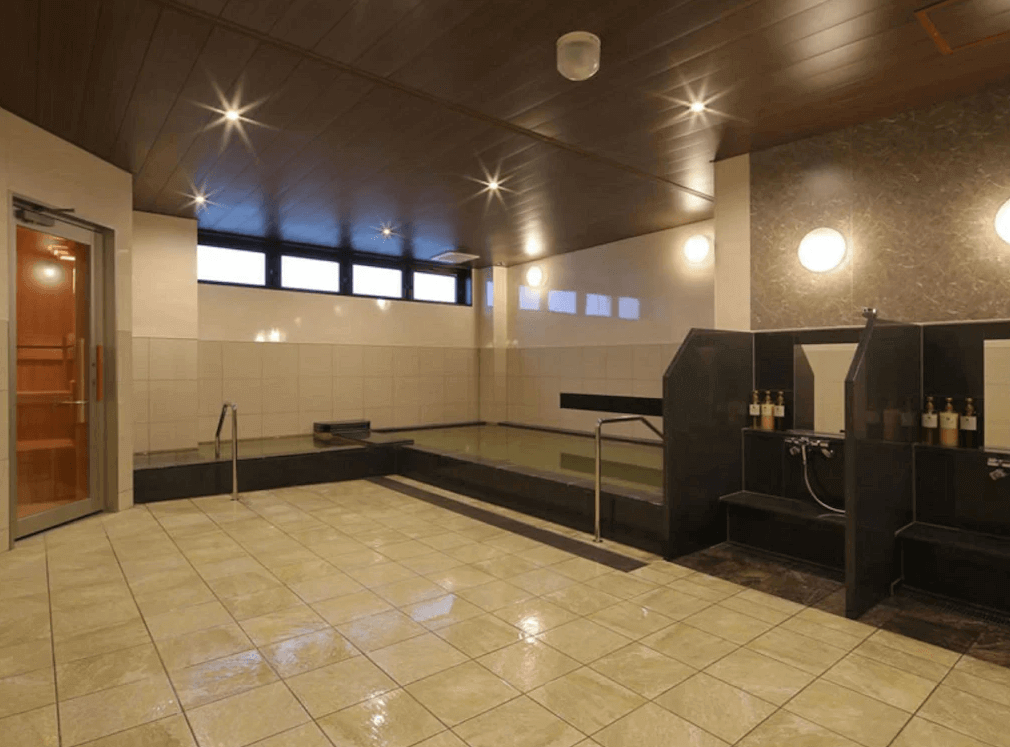 【奄美大島住宿】「Hotel West Court Amami 2 大浴場：寬敞明亮的公共浴池，設有泡湯池、淋浴區與乾濕分離空間，可供旅客放鬆身心。」