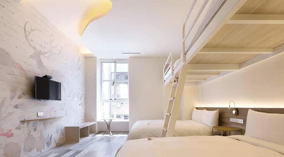 【台中火車站住宿】「MINI HOTELS 台中火車站館的親子四人房，房內設有上下舖設計與兩張大床，搭配鹿森林系壁畫與柔和燈光，空間明亮溫馨，適合親子入住。」