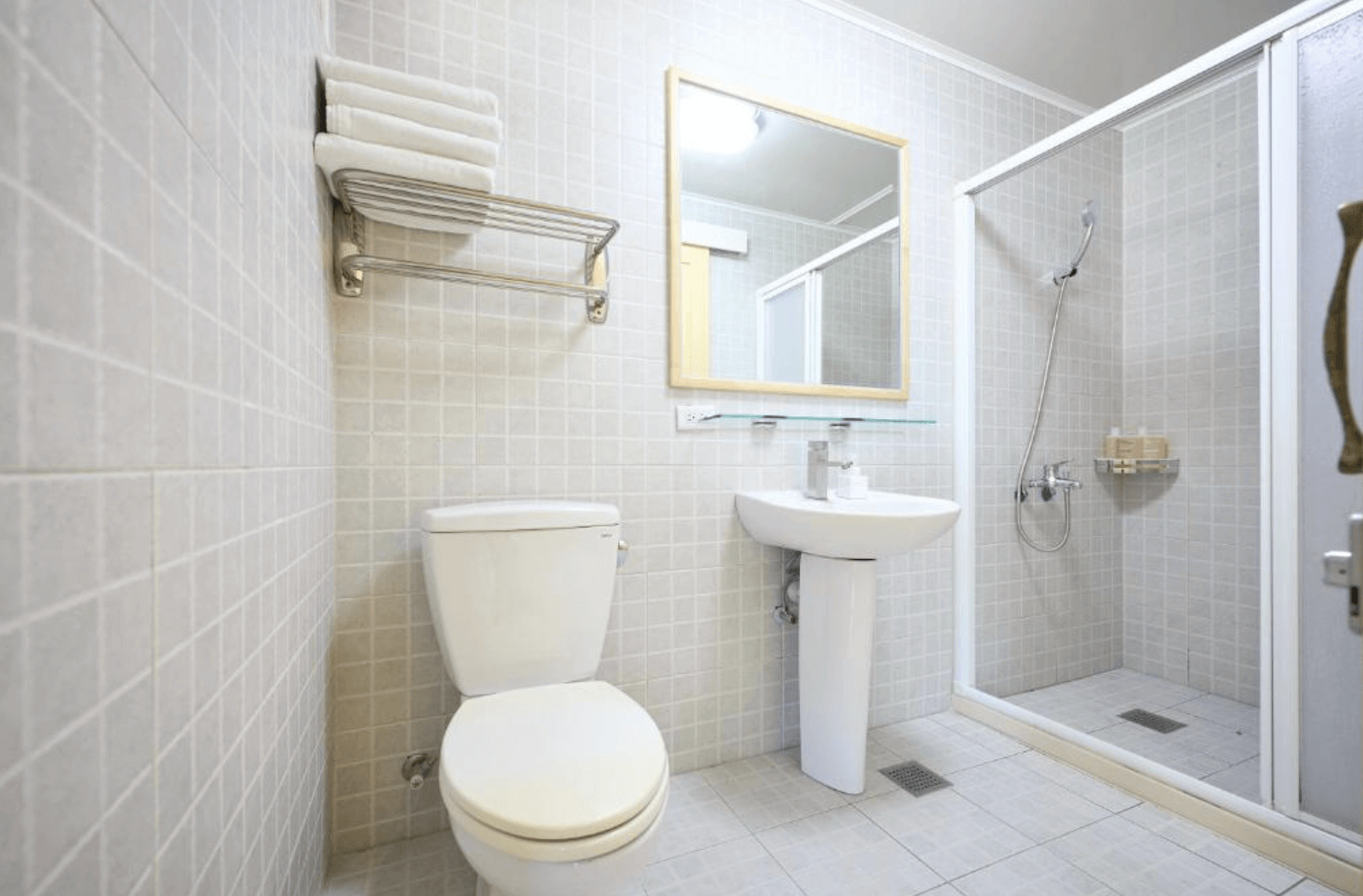 【東華大學民宿】「OwlStay故事所 綠舍」浴室，採用淺灰色方格磁磚設計，乾濕分離空間配置洗手台與馬桶，整體潔淨明亮，風格簡約。