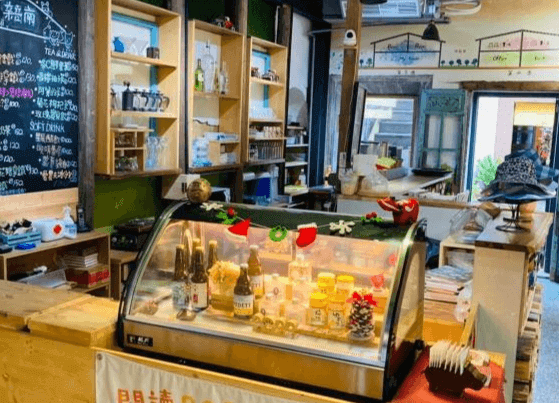 【大溪住宿】「湧山水民宿 Sinnan 12 Homestay — 咖啡吧檯區，展示冰櫃與飲品，周圍擺放手作器皿與書籍，呈現結合咖啡館與民宿的獨特氛圍。」