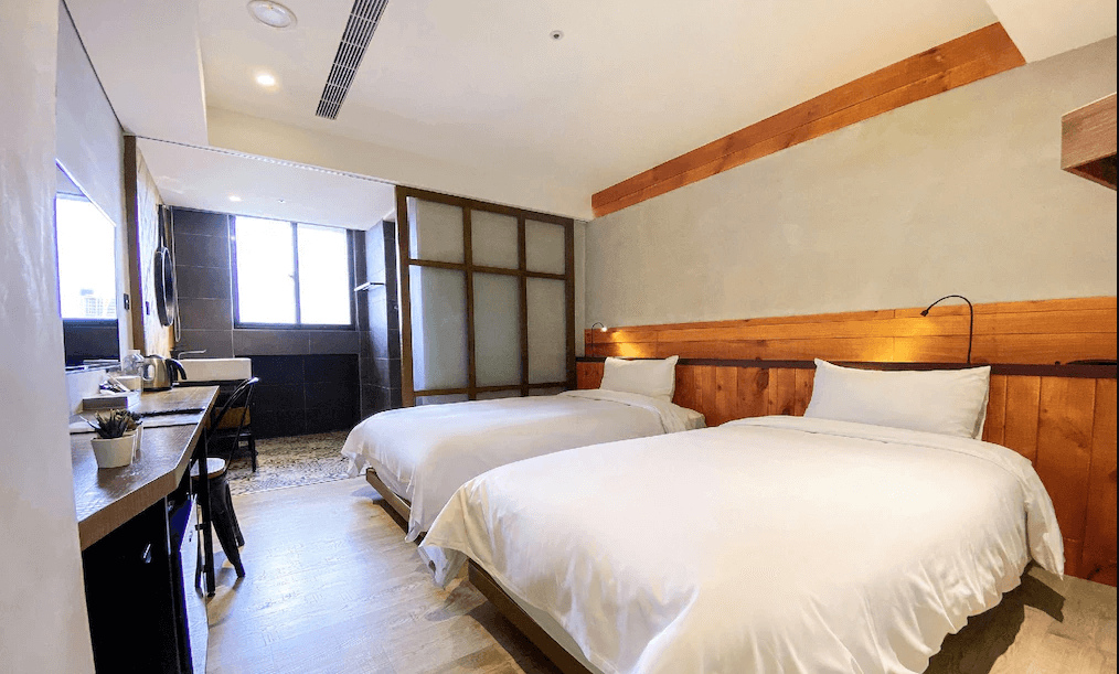 【台中火車站住宿】「old school 行旅・田中央旅店的雙床房，木質牆面與簡約水泥風格結合，房內設有書桌、洗手台與大片窗戶，呈現溫暖而帶有設計感的住宿空間。」