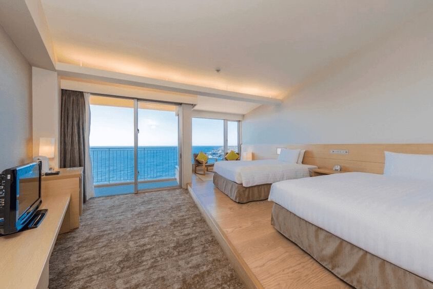 【屋久島住宿】「samana hotel Yakushima 薩馬納飯店屋久島的海景雙床房，設有大片落地窗與陽台，可直接眺望無敵海景，房間以明亮木質色調打造舒適開闊感。」
