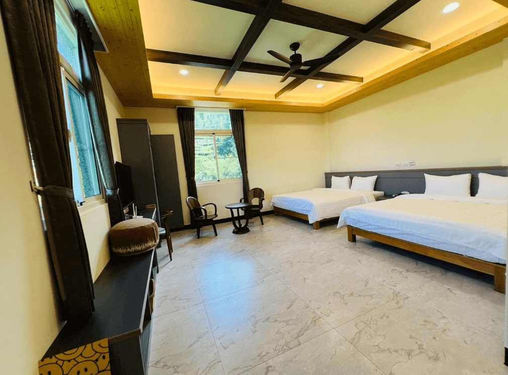 【瑞里住宿】「一品茶業民宿雙人房｜房內空間寬敞明亮，兩張大床搭配木質天花與暖色燈光，窗外可見山林景色，營造放鬆氛圍。」