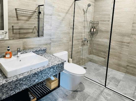 【瑞里住宿】「一品茶業民宿浴室｜乾濕分離設計，石紋牆面搭配玻璃淋浴間與大理石洗手台，整潔明亮。」