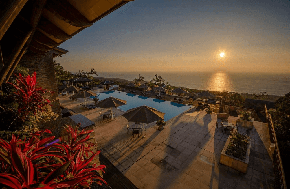 【屋久島住宿】"屋久島住宿精選示意圖"「三卡拉羅久島Spa酒店 Sankara Hotel & Spa Yakushima 露天泳池區，可欣賞壯麗海上夕陽景色，周圍設有躺椅與遮陽傘，是度假放鬆的絕佳場所。」