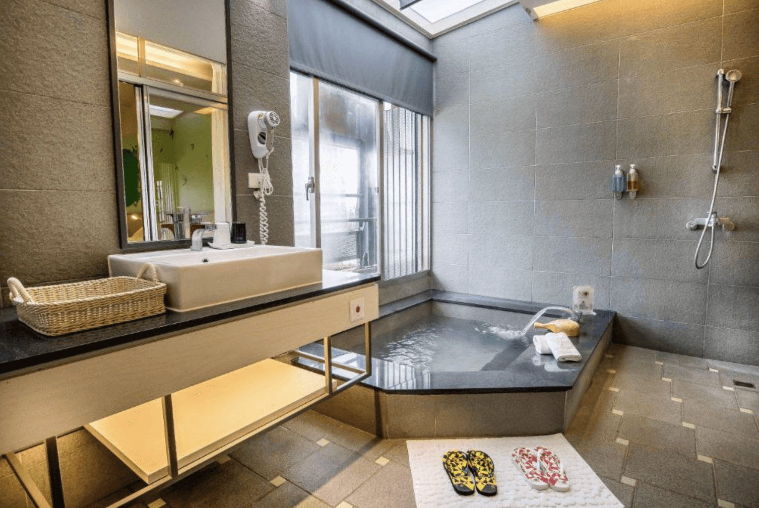 【宜蘭溫泉飯店】「九號溫泉旅店浴室與泡湯池空間，設有大理石溫泉池、乾濕分離淋浴區與洗手台，空間明亮潔淨，營造放鬆的溫泉體驗。」