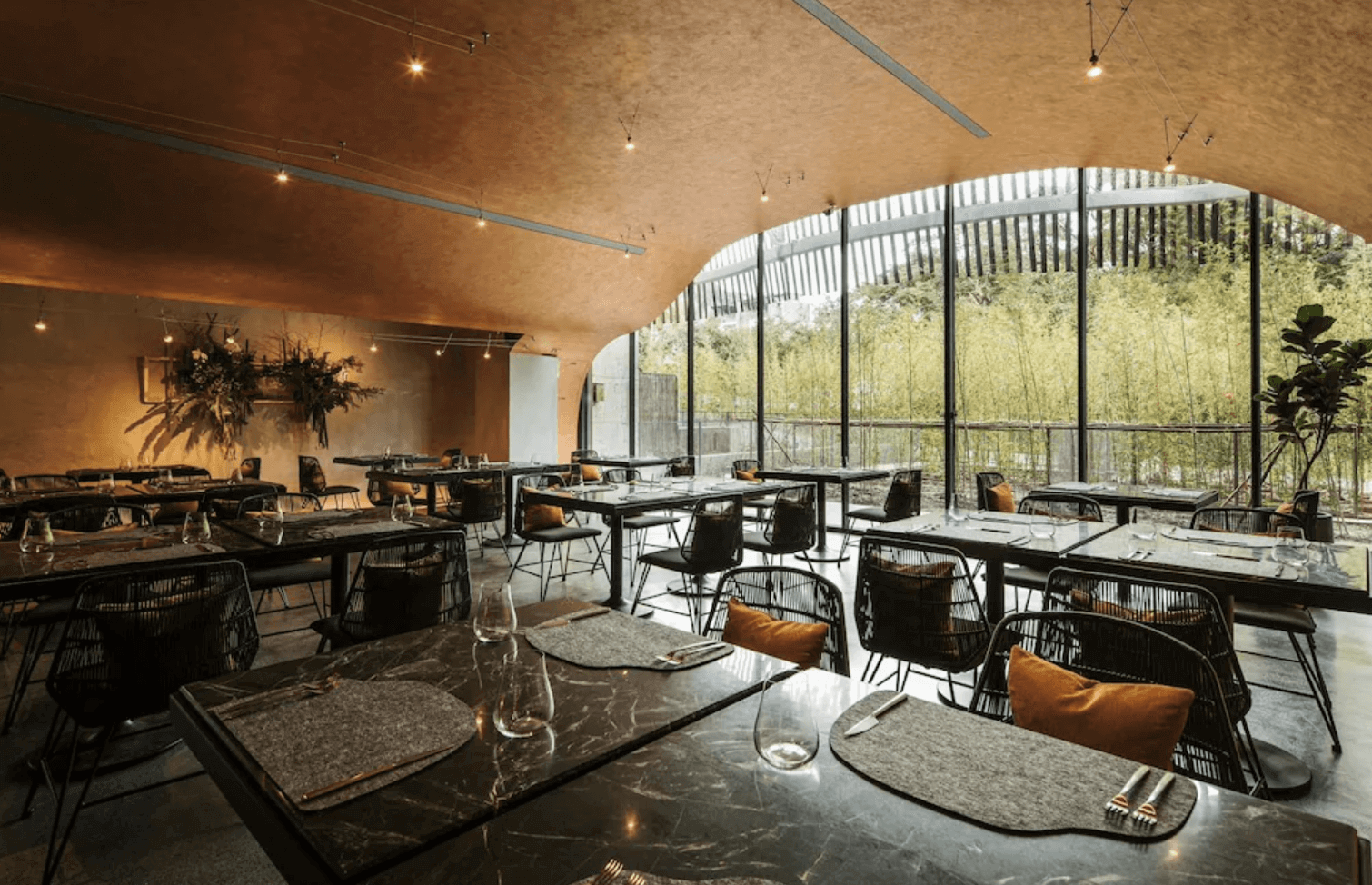 【宜蘭溫泉飯店】「了了礁溪 VIVIR Jiaoxi 餐廳空間，以弧形天花板與大片落地窗為特色，採用沈穩大地色調與質感家具，窗外可見竹林景觀，呈現高質感用餐氛圍。」