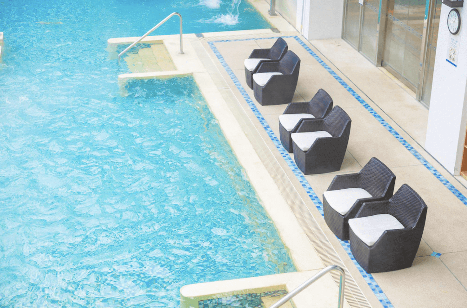 【宜蘭溫泉飯店】「品文旅的室內水療池區域，湛藍池水搭配置放整齊的白色靠墊休憩椅，營造明亮放鬆的戲水氛圍，適合旅客休閒放鬆。」
