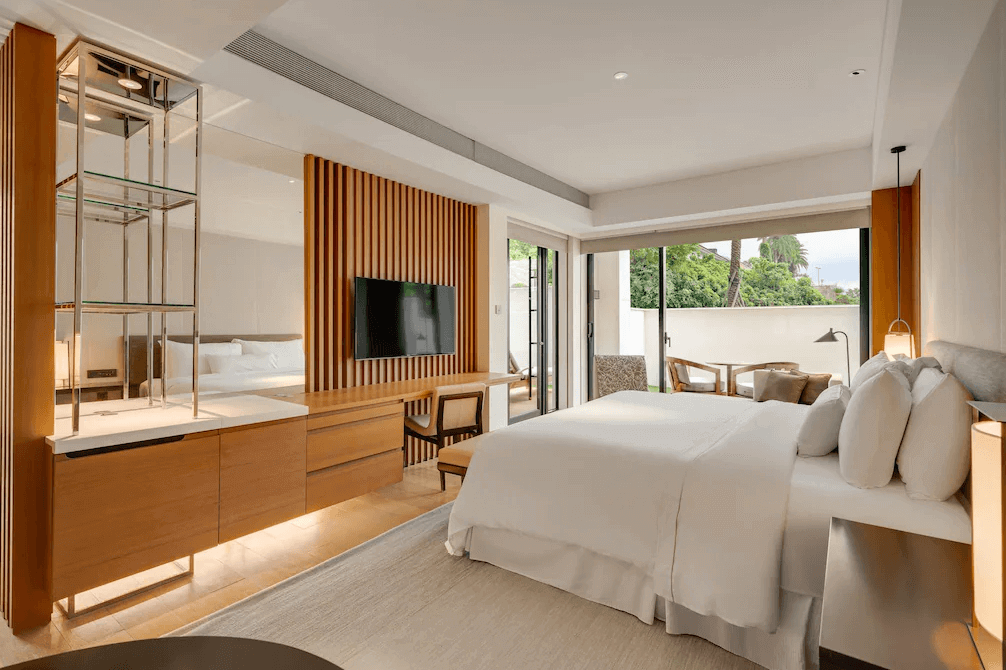 【大溪住宿】「大溪笠復威斯汀度假酒店 — 現代風格豪華客房，溫潤木質設計搭配米白色床鋪，採光充足並連通戶外陽台，展現舒適放鬆的住宿氛圍。」